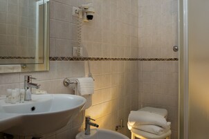 Un bagno con lavandino, specchio e WC.
