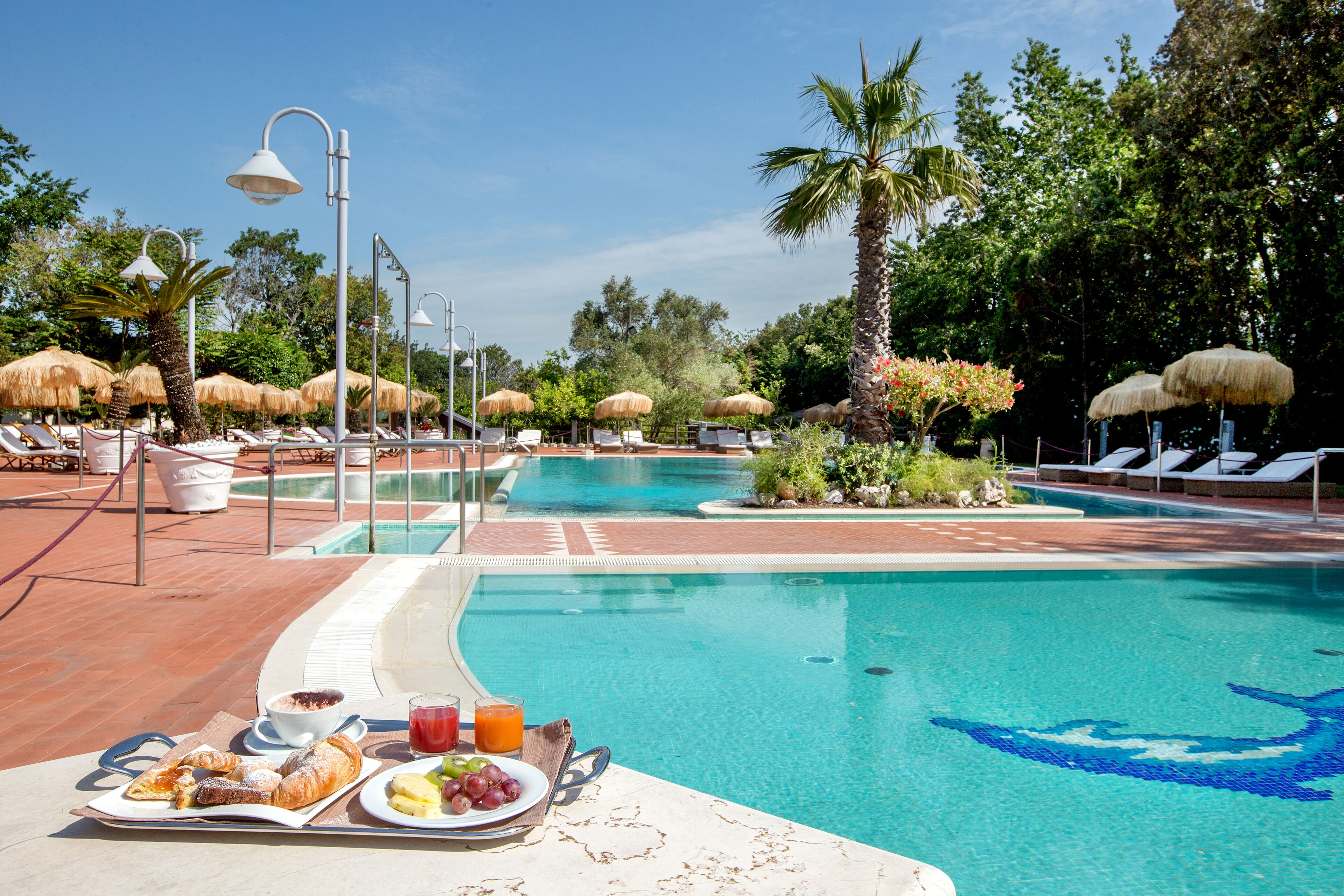 Una piscina al aire libre de temporada, sombrillas