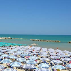 Aan een privéstrand, ligstoelen, parasols, een strandbar