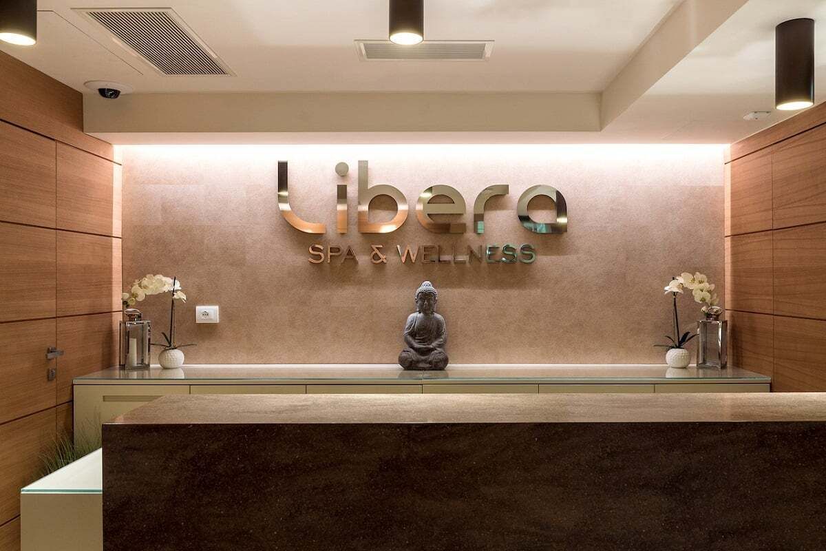A reception desk with a sign reading "Libere SPA & WELLNESS".