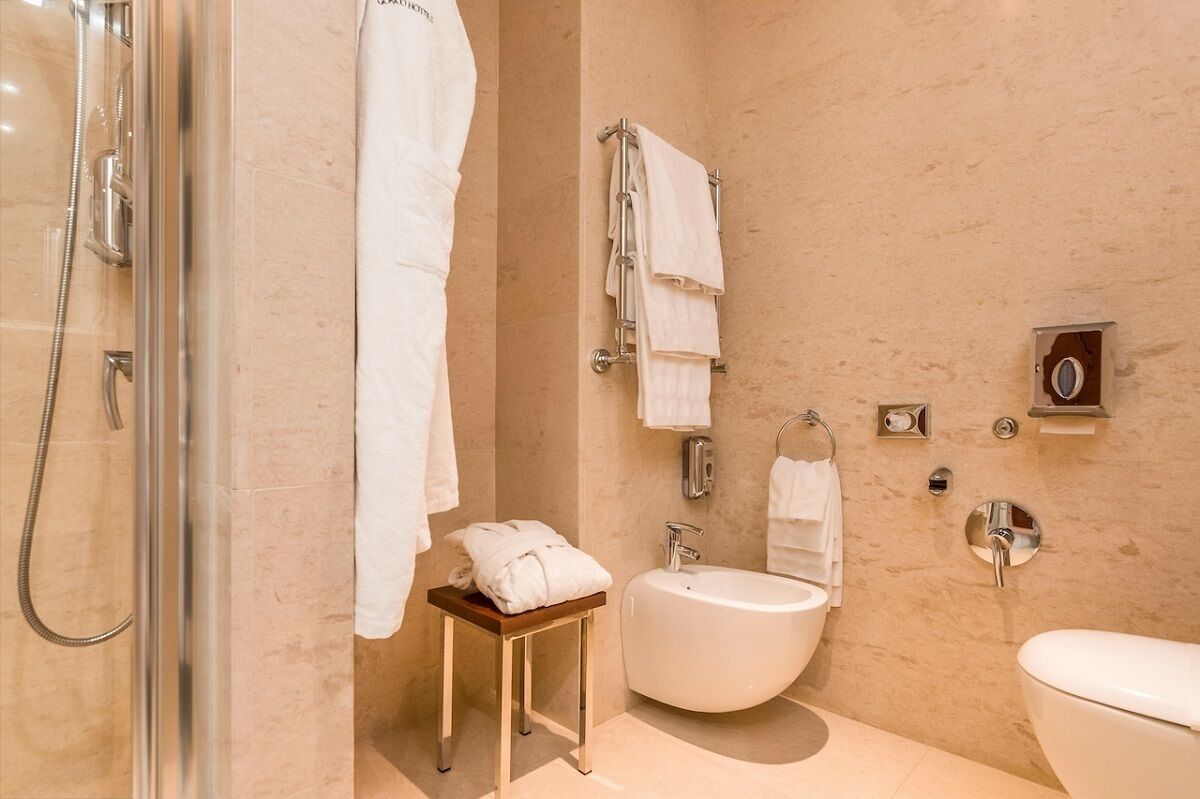 A modern bathroom with a glass-enclosed shower, a freestanding bathtub, a sink, and a toilet.