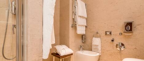A modern bathroom with a glass-enclosed shower, a freestanding bathtub, a sink, and a toilet.