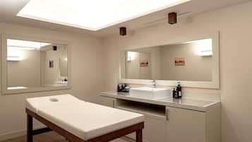 Une salle de bain moderne avec un grand miroir, un lavabo blanc et un banc en bois.