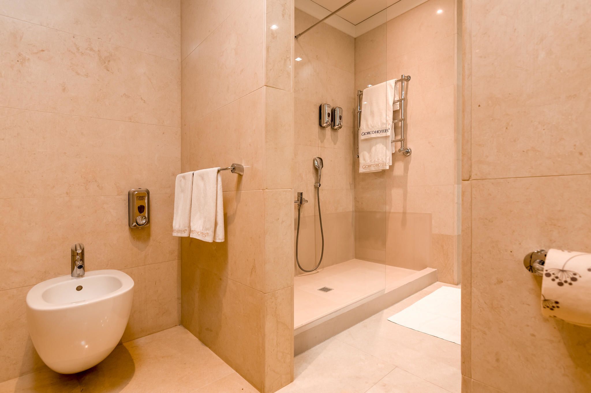 Un baño moderno con lavamanos, ducha y perchero.