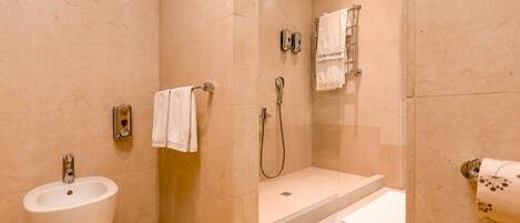 Un baño moderno con lavamanos, ducha y perchero.