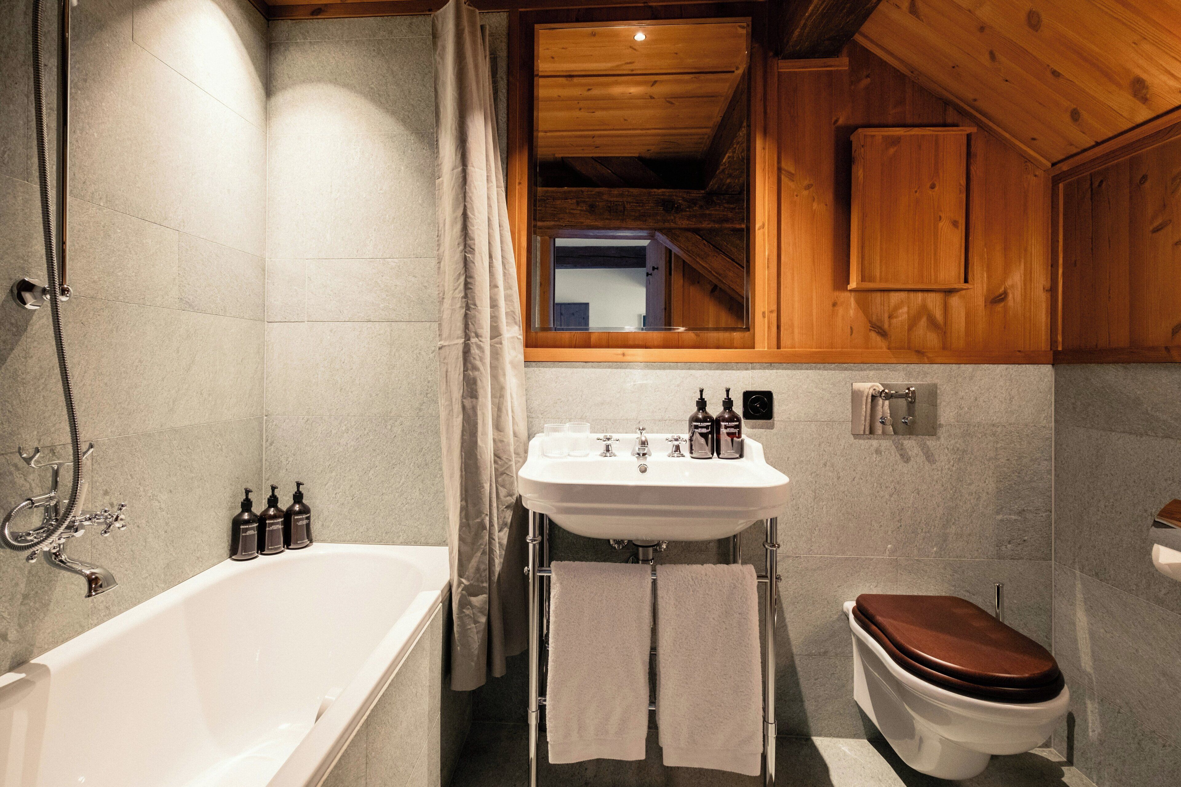 A bathroom with a bathtub, a toilet, and a sink.
