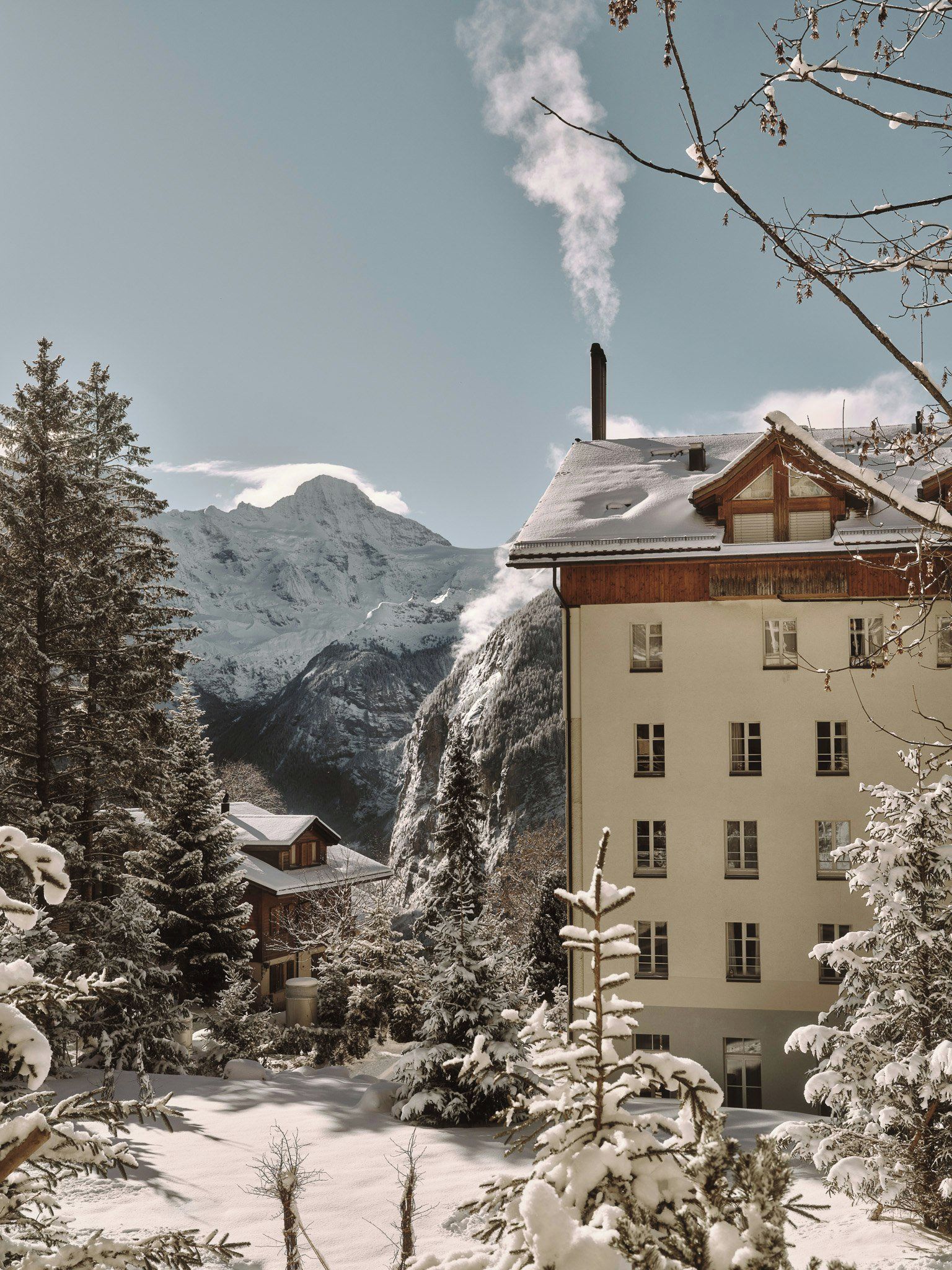 Ein schneebedeckter Berg mit einem Gebäude im Vordergrund.