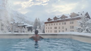 Alberca techada, alberca al aire libre y sombrillas en la alberca