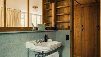 A bathroom with a white sink, wooden cabinets, and a large mirror.
