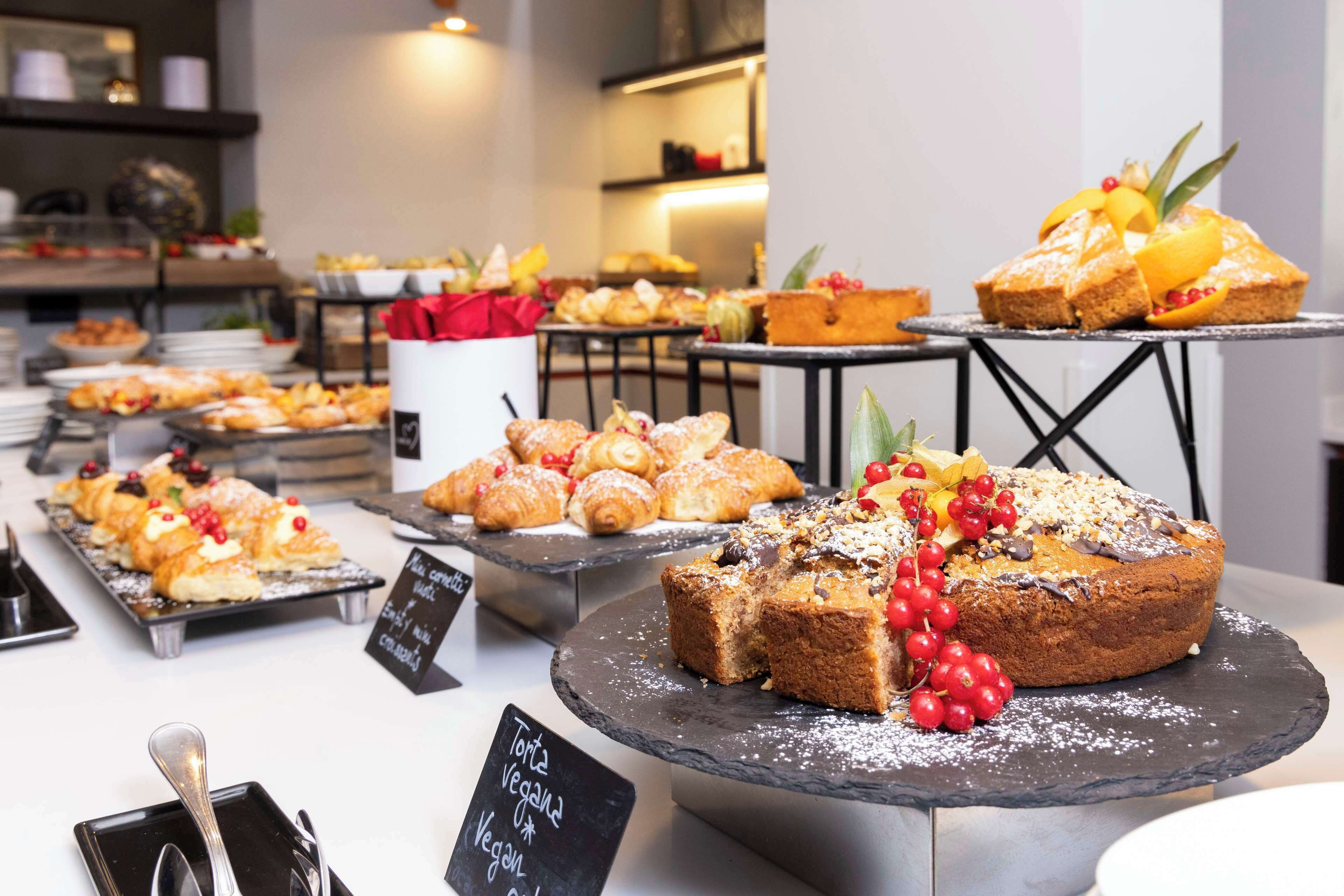 A buffet with various desserts and pastries, including vegan options, displayed on multiple serving boards.