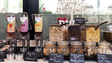 Un buffet de petit-déjeuner proposant une variété d’aliments, notamment des céréales, des noix et du miel.