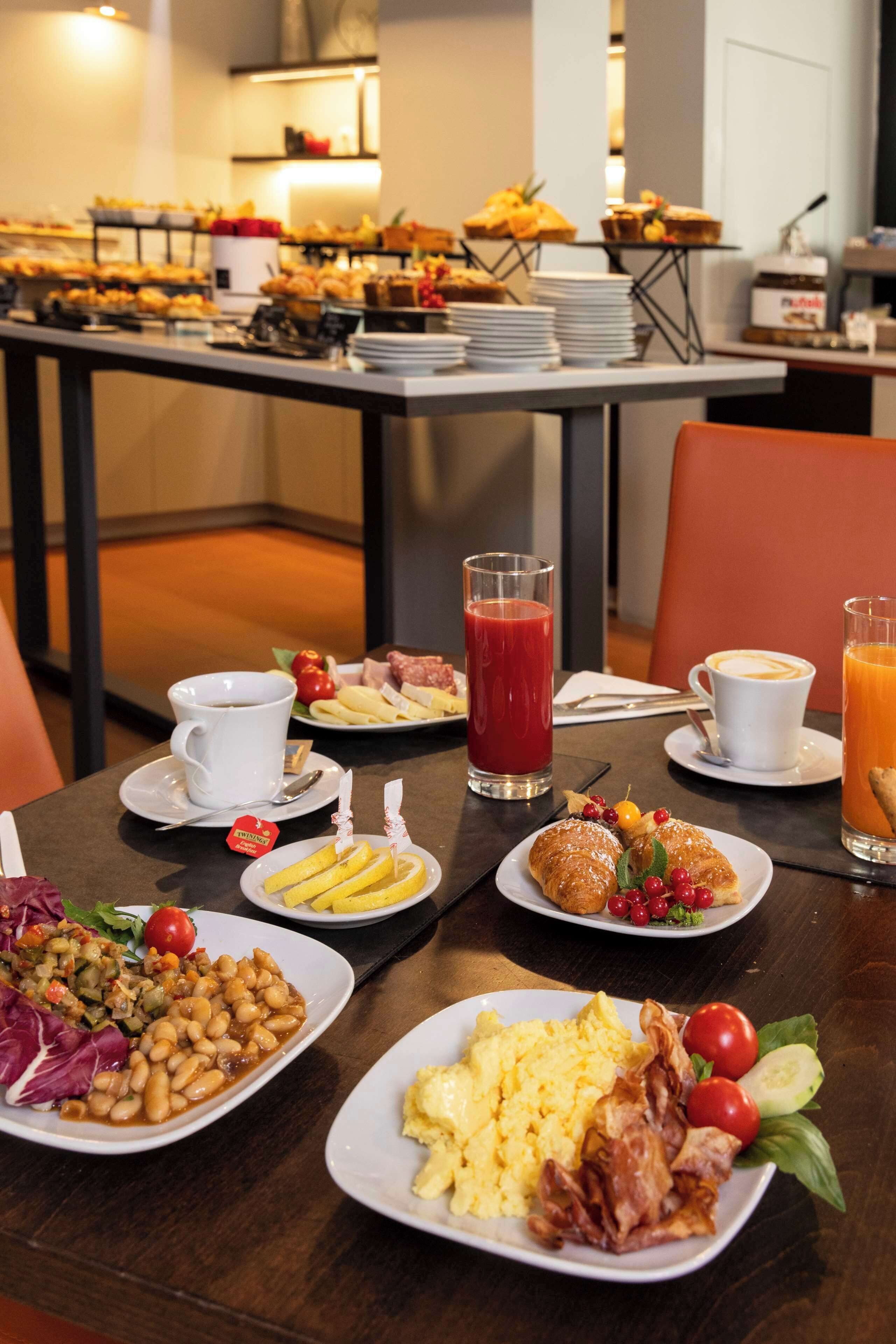 A breakfast buffet with various dishes, including eggs, bacon, and fresh fruits.