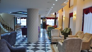 A lobby with checkered flooring, multiple seating areas, and a staircase. - Tayhan Hotel (Istanbul)