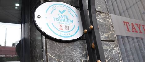 A sign indicating a "CERTIFICATE OF SAFE TOURISM" for the Tayhan Hotel in Turkey.