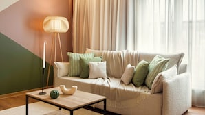 A living room with a sofa, pillows, a lamp, and a table. -  Zeus Essence Bucharest, Trademark Collection by Wyndham (Bucharest)