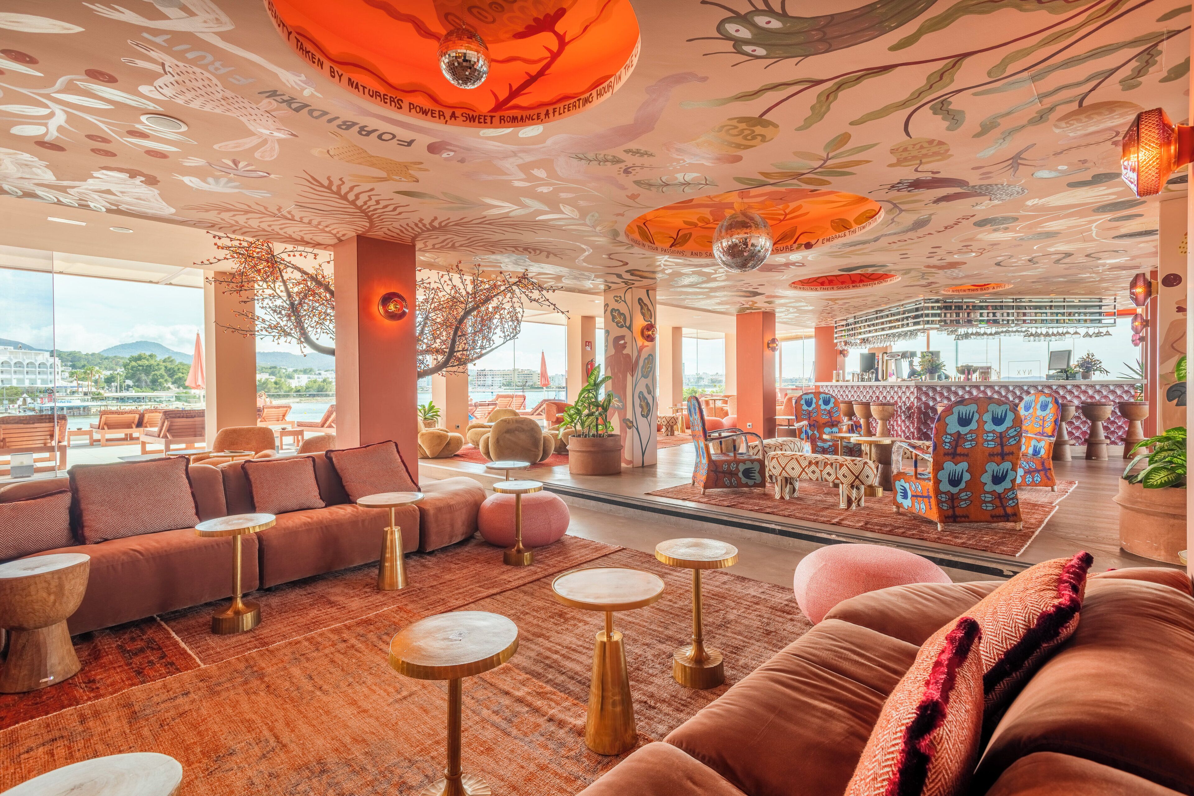 Ein großzügiger Lounge-Bereich mit Bar, bequemen Sitzgelegenheiten und Blick auf die Stadt.