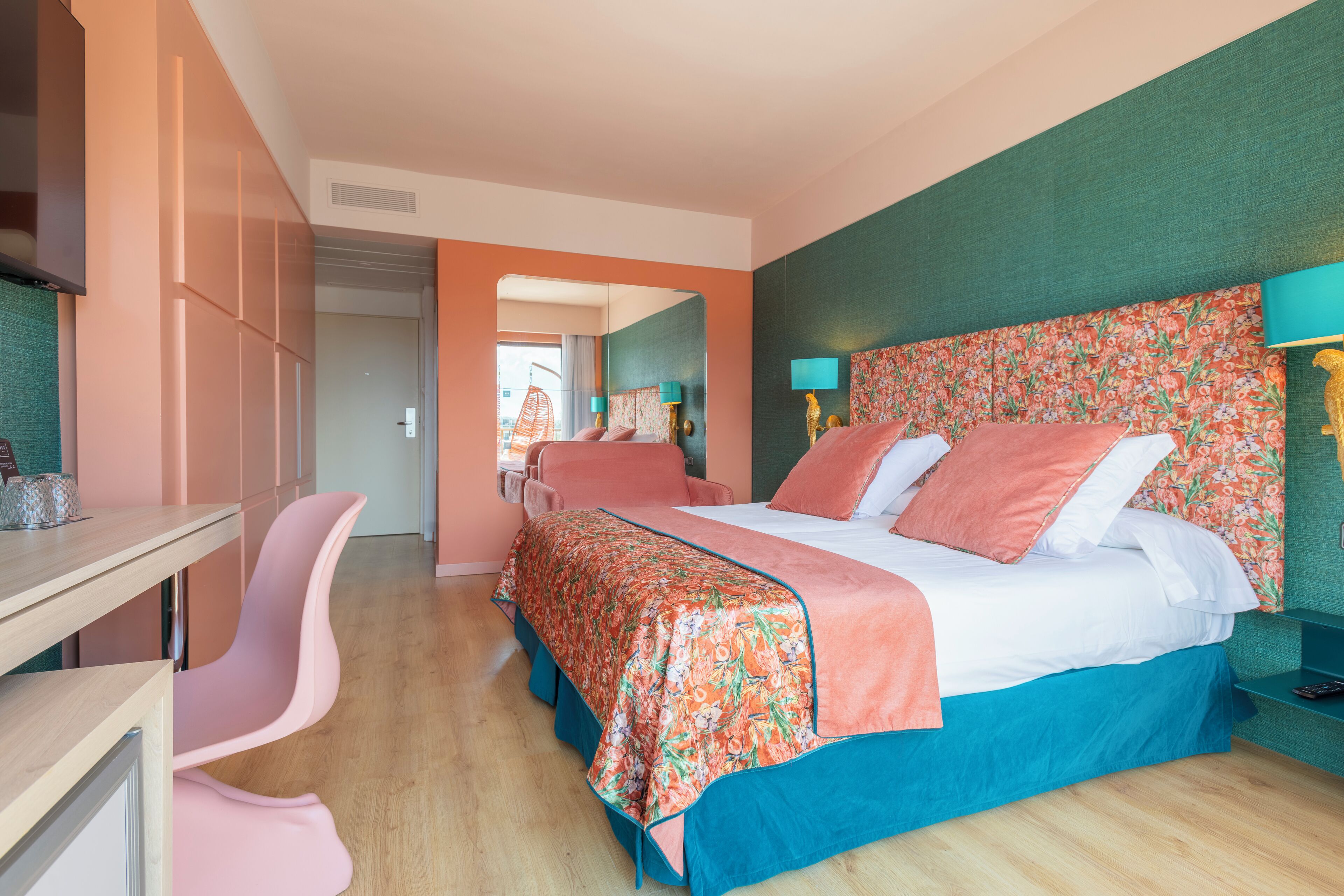 Una habitación de hotel moderna con una cama grande, un escritorio y una silla.