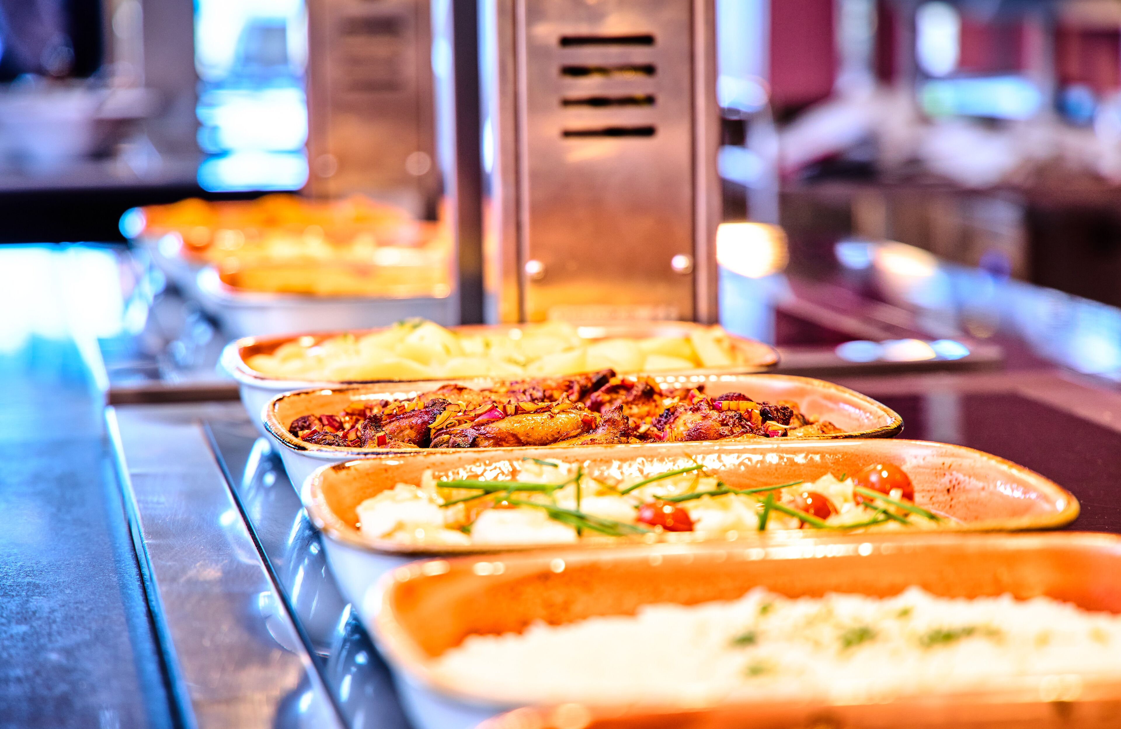 A buffet with various dishes including pasta, salads, and meats.