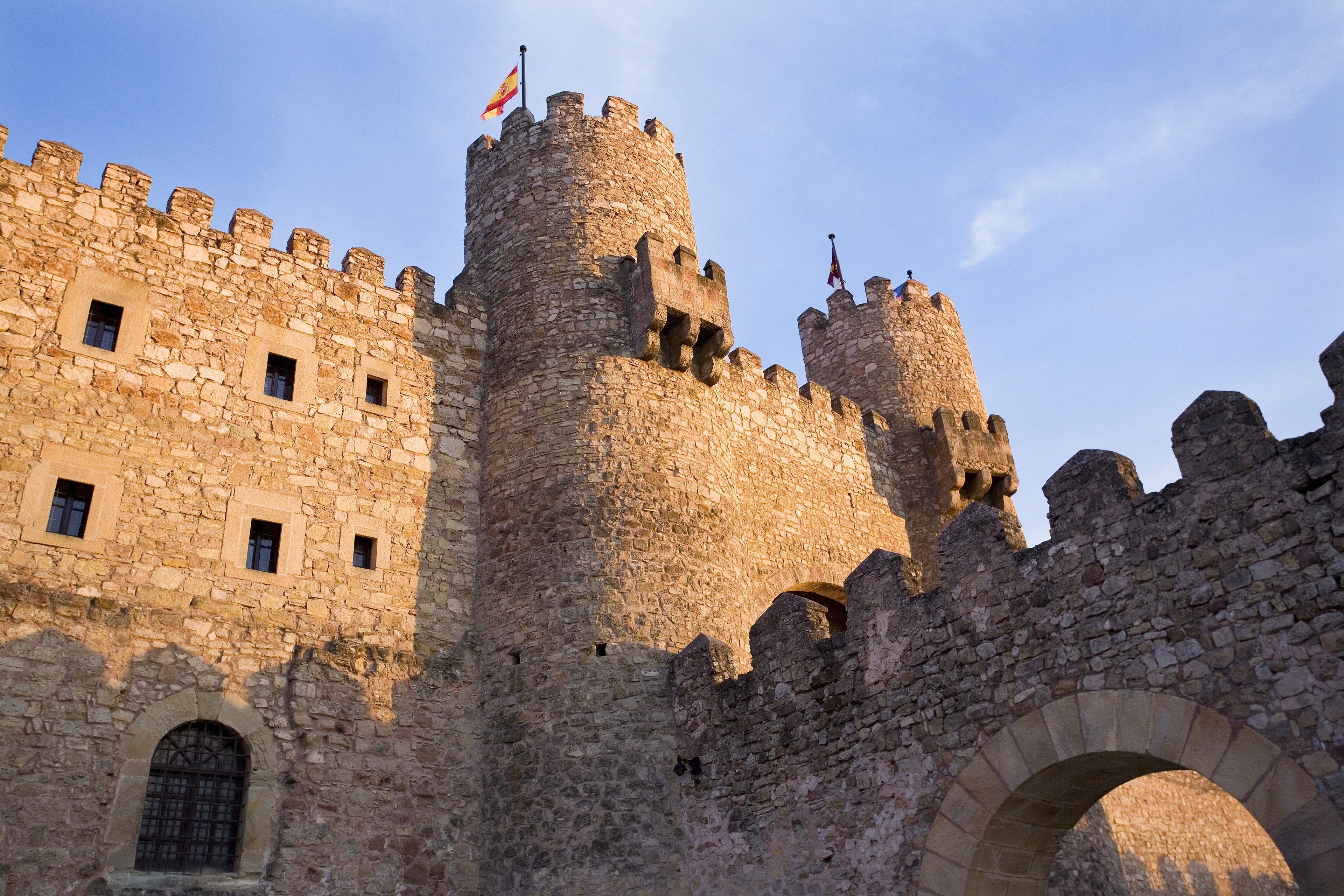 A historic stone castle with multiple towers and arched windows.