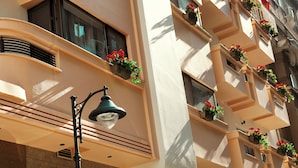 A building facade with multiple balconies adorned with flower boxes and a street lamp. - Zeus Essence Bucharest Opera (Bucharest)