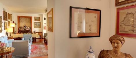 A room with a wooden table, chairs, a rug, and framed pictures on the wall.