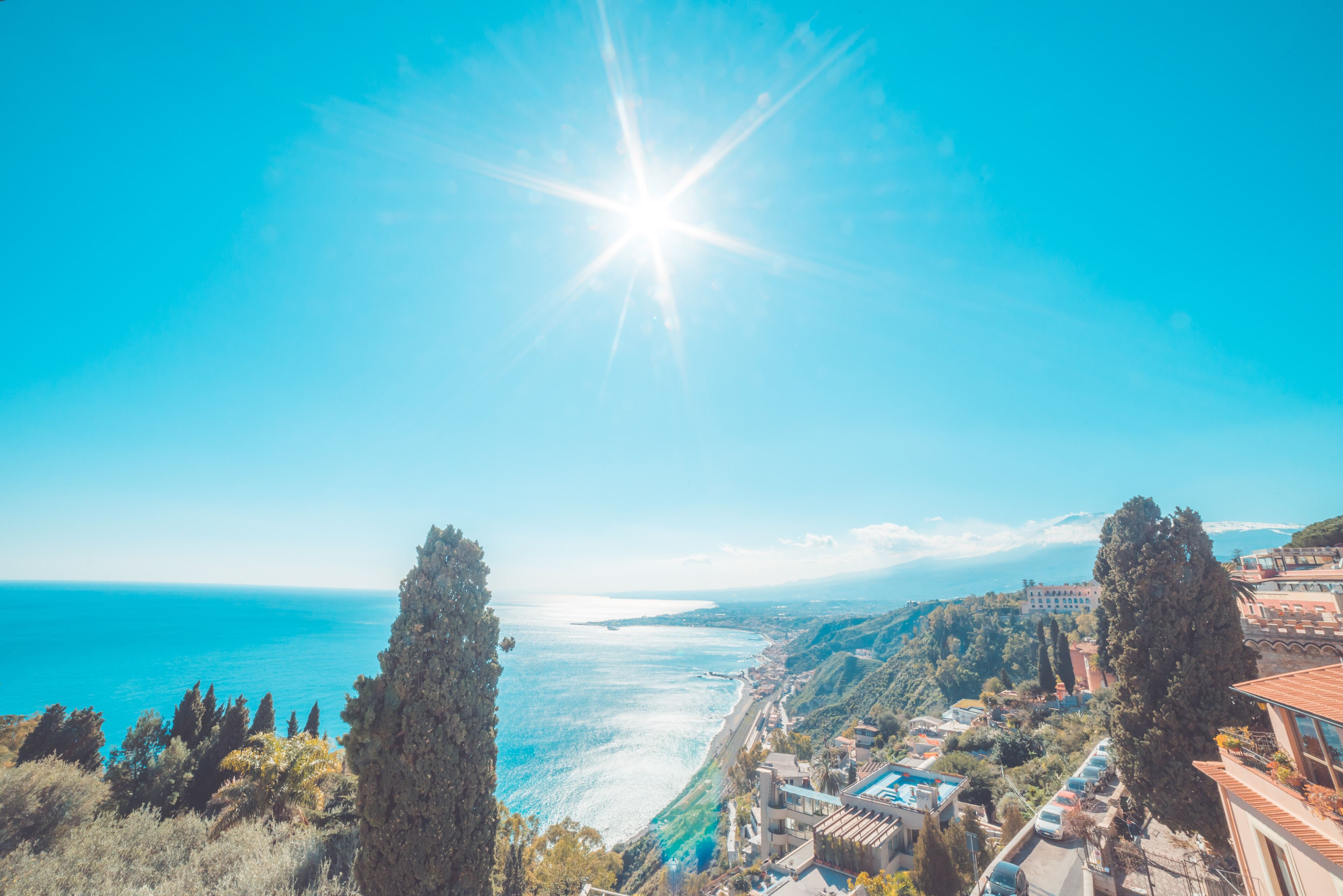 Une ville côtière offrant une vue dégagée sur la mer, les bâtiments et les arbres.
