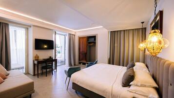 Een moderne hotelkamer met een groot bed, een bureau, een televisie en een balkon.