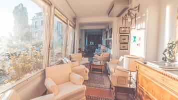 Ein geräumiges Wohnzimmer mit großem Fenster, Kamin und Blick auf die Stadt.