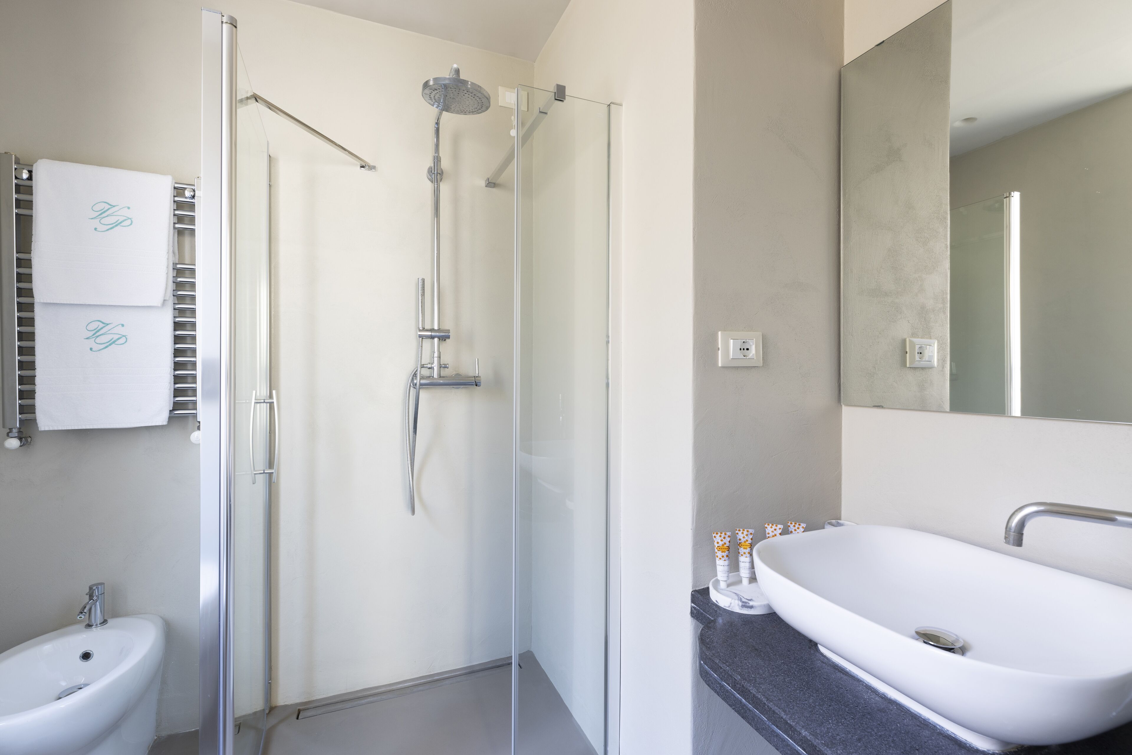 Une salle de bain moderne avec une douche à parois de verre, un lavabo blanc et des toilettes.