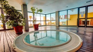 A hot tub on a wooden deck with large windows and potted plants. - SBH Club Paraíso Playa - All Inclusive (Pajara)
