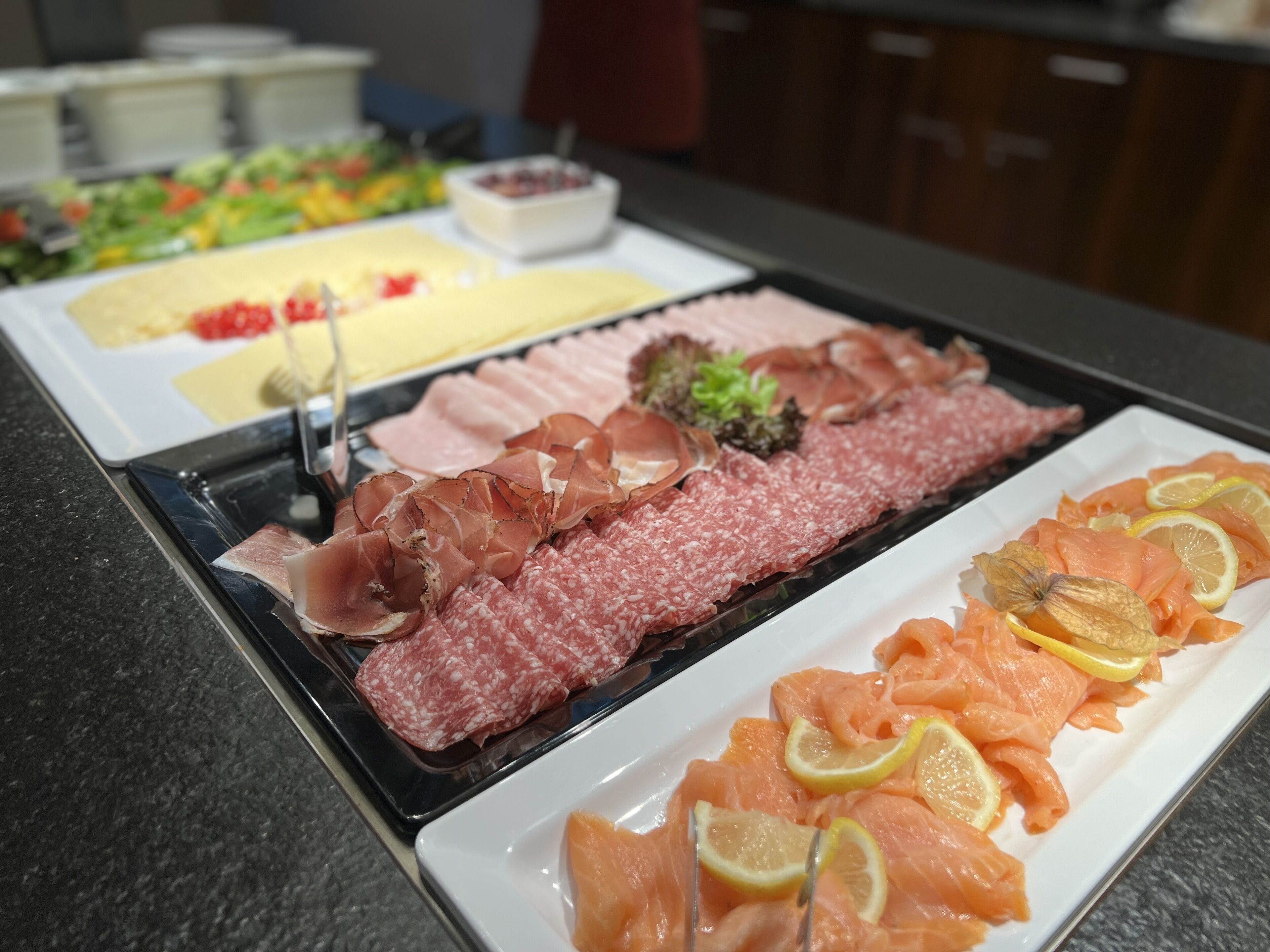 Een buffet met diverse vleeswaren en gerookte zalm.