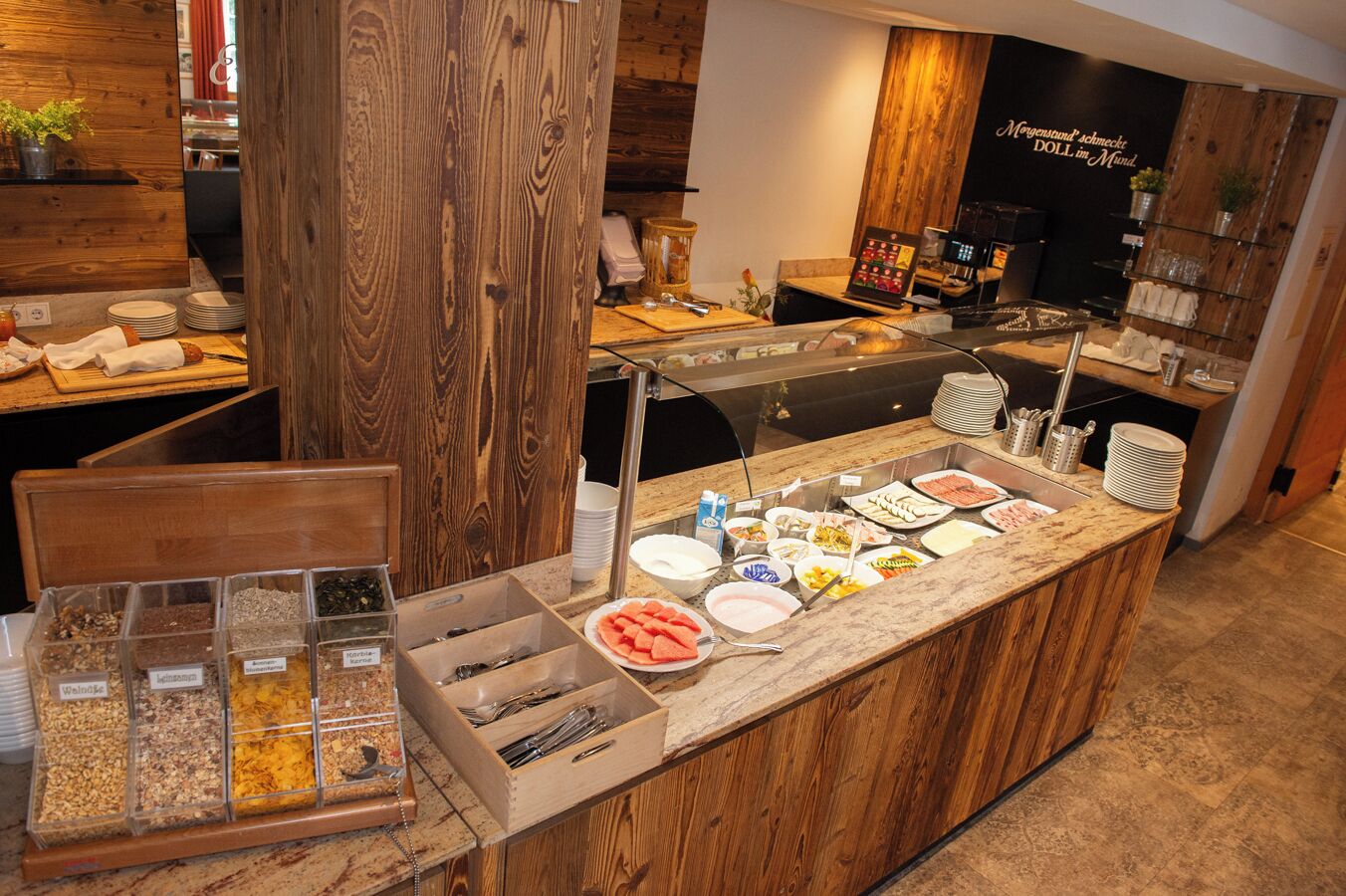 A buffet area with various food options, including fruits, salads, and cereals.