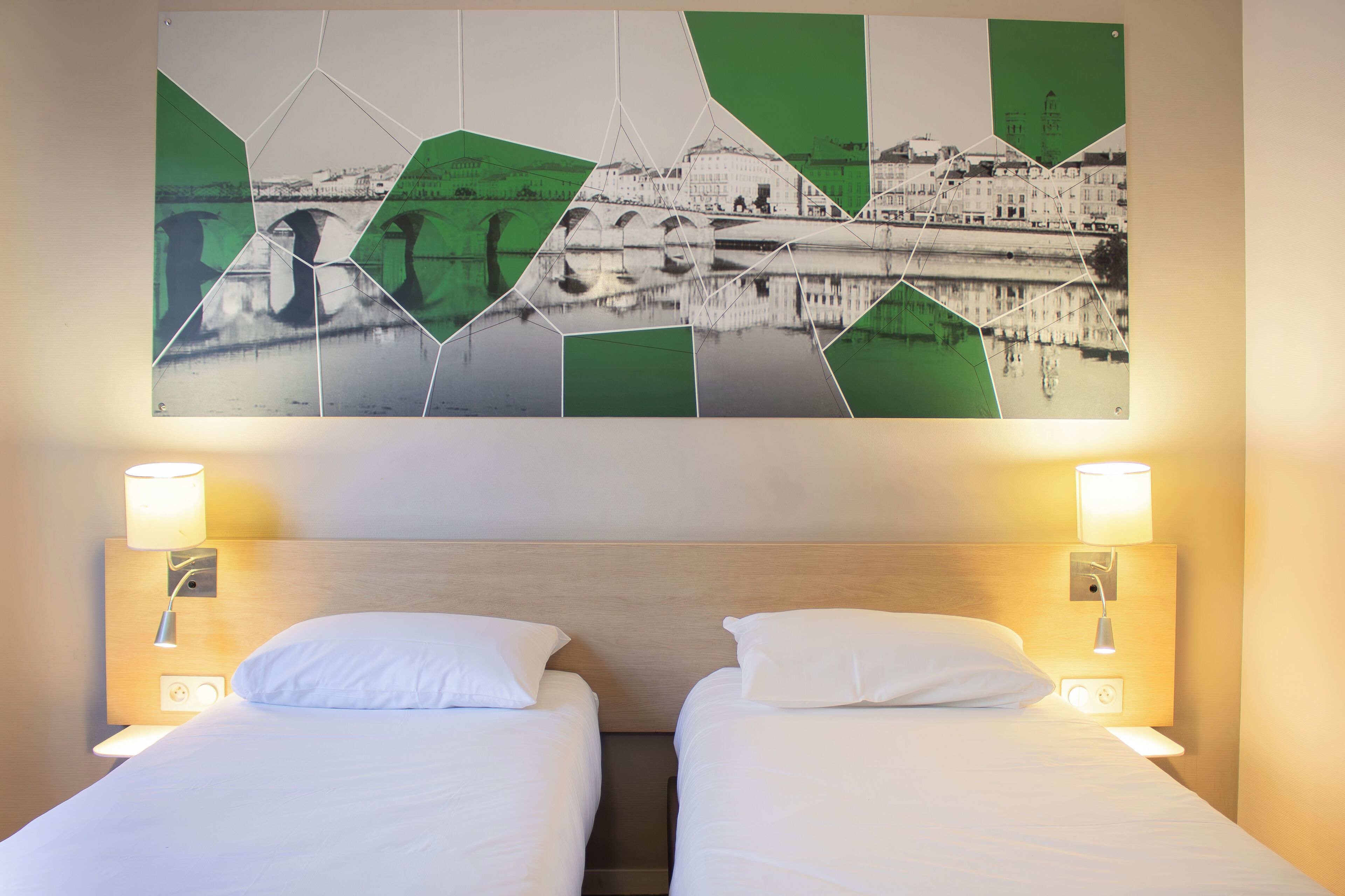 A hotel room with two beds, a wooden headboard, bedside lamps, and a large abstract painting on the wall.