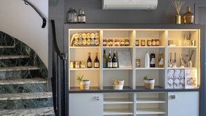 Un interior moderno con una escalera de mármol, una vitrina bien iluminada con diversos objetos y un diseño limpio y minimalista.