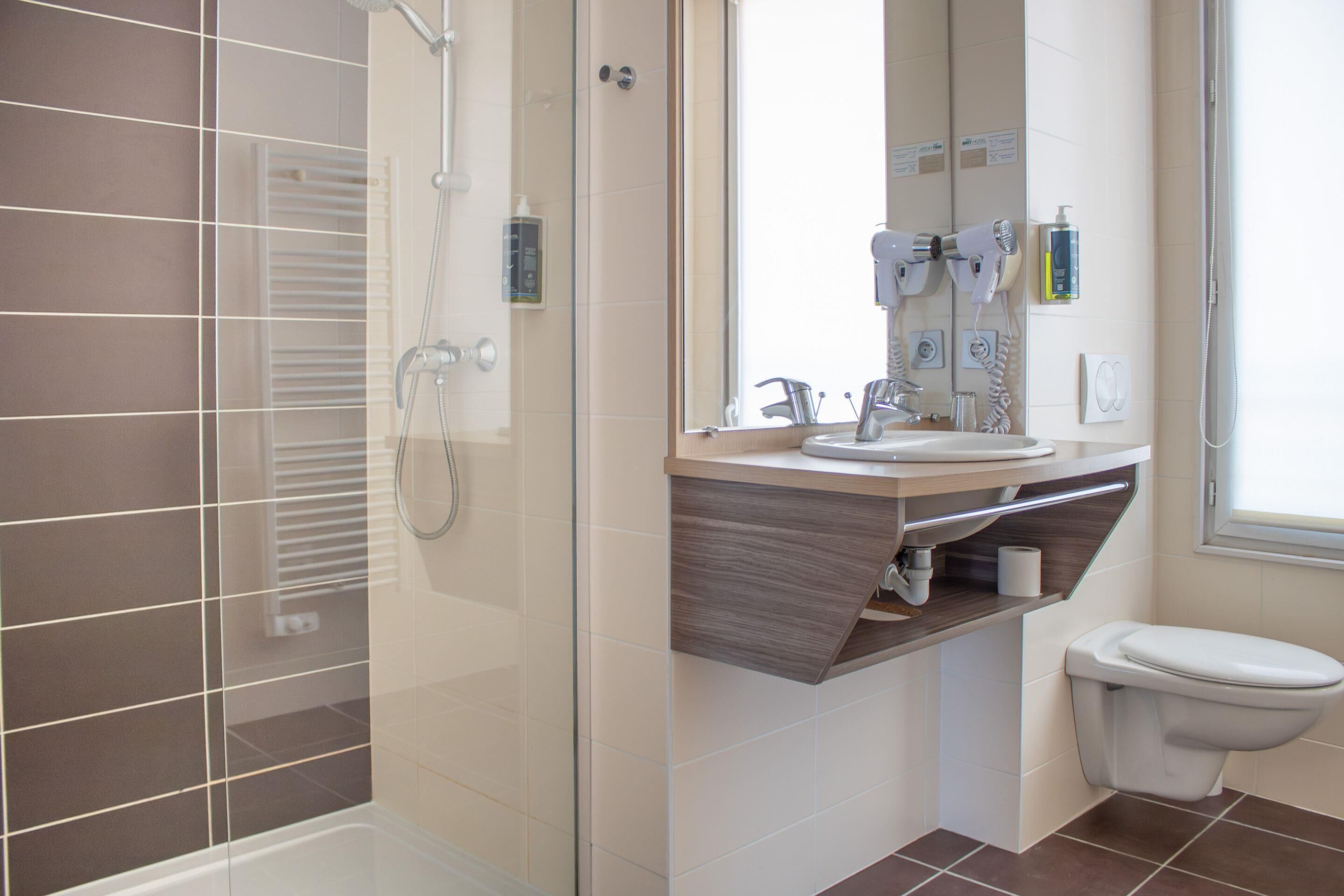 Une salle de bain moderne avec une douche à parois de verre, un meuble-lavabo avec un miroir et des toilettes.