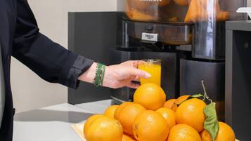 Une personne verse du jus d’orange d’un distributeur dans un verre.