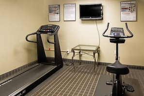 A gym with treadmills and an exercise bike, a TV, and informational posters on the wall. - Quality Inn Plainfield I-395 (Plainfield)