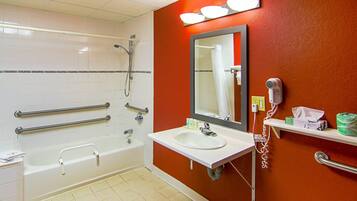 A bathroom with a bathtub, a sink, a mirror, a shower, and a hand dryer.