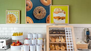 A kitchen counter with various food items, a toaster, and a display case with baked goods.