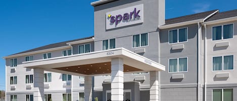 A hotel with a clear sky, a covered entrance, and a sign reading 'Spark by Hilton'.