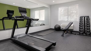 A gym with a treadmill, exercise ball, and weight rack. - Spark by Hilton Douglasville Atlanta West (Douglasville)