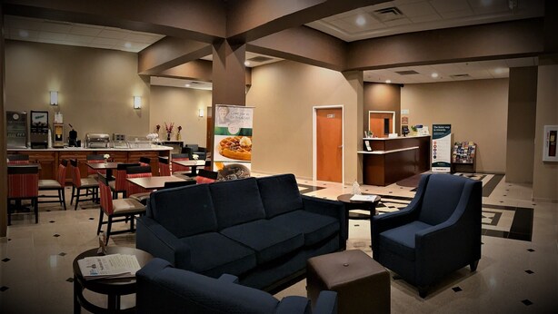 A hotel lobby with a bar area, seating arrangements, and a reception desk.
