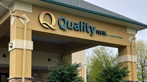 A hotel sign with the name "Quality Inn by Choice Hotels".