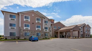 A multi-story hotel with a stone facade, large windows, and a covered entrance area. - Comfort Suites Delavan - Lake Geneva Area (Delavan)