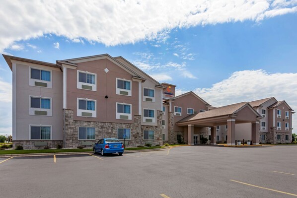 A multi-story hotel with a stone facade, large windows, and a covered entrance area.