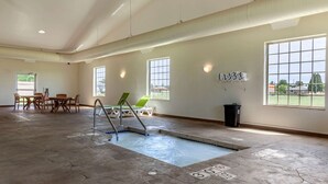 A spacious indoor pool area with a diving board, lounge chairs, and a view of the outside through large windows. - Comfort Suites Delavan - Lake Geneva Area (Delavan)
