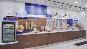 Un área de desayuno con un letrero que dice 'EXPRESS START BREAKFAST' y diversas opciones de comida, como fruta, cereales y alimentos calientes.