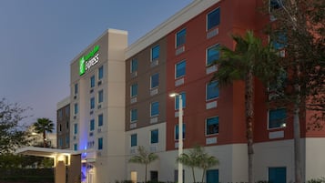 Experience the Radisson Express, a stylish hotel with a modern design and lush palm trees.