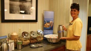 A buffet setup with various food containers and utensils.