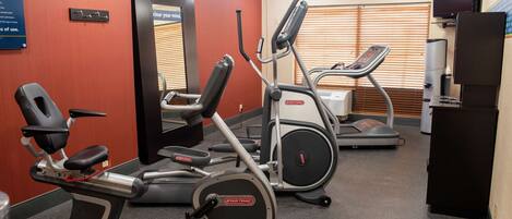 A gym with various exercise equipment including treadmills, an elliptical, and a stationary bike.